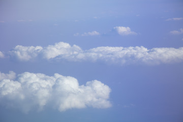 Aerial view from plane window with blue sky and white clouds