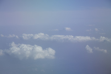 Aerial view from plane window with blue sky and white clouds