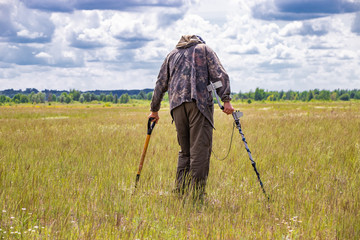 Treasure hunter in the field with a metal detector
