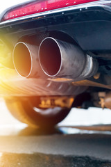Powerful car with exhaust pipe, pollution and fine dust. Sunlight.
