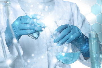 Closeup view of scientist pouring color liquid from beaker into flask, double exposure. Solution...