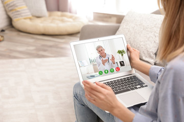 Young woman using video chat on laptop in living room, closeup. Space for design