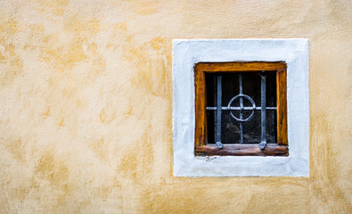 old window with wooden frame and forged lattice