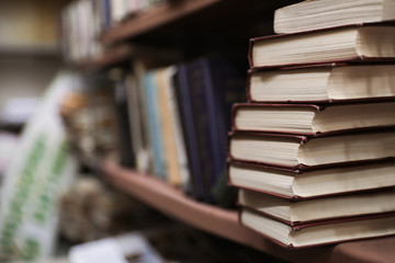 Cabinet with collection of books in library. Space for text