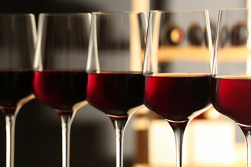 Glasses of red wine in cellar, closeup. Expensive drink