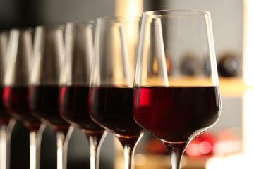 Glasses of red wine in cellar, closeup. Expensive drink