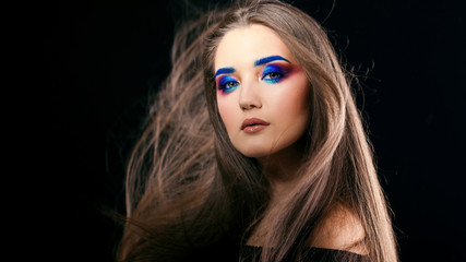 Fototapeta premium Portrait of a gorgeous beautiful girl with long hair and blue smoky eyes.