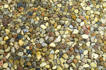 Stones of different colors and sizes: light, black, blue, light yellow, dark red, tightly pressed together
