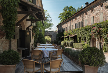 table and chairs of restaurants in front of historic ancient place medieval village - italian relax and style life - Piacenza - Emilia Romagna, Italy.