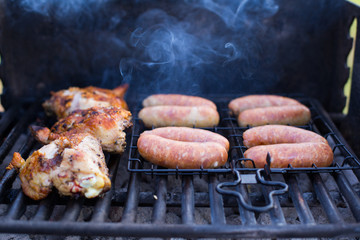 Summer barbecue, grilling sausages and chicken