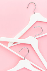 White hangers on pastel pink background