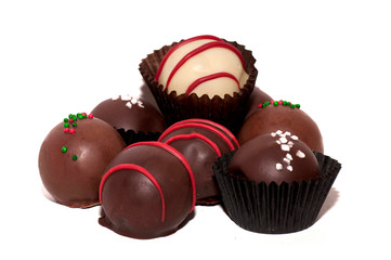 Variety of brown and white chocolates with red, green, and white decorations against a white background.