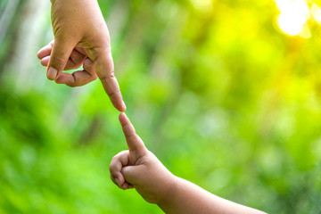 Mother is holding hands with boy boy in the wild