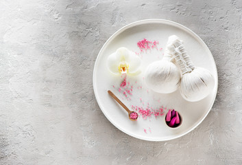 Spa orchid massage Aromatherapy body care. Herbal massage balls, sea salt and incense sticks, top view, flat lay on concrete background