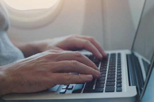 Using Onboard Internet On Laptop In Airplane, Passenger Working On Computer In  Plane, Closeup Of Hands Typing On Keyboard Inside Aircraft