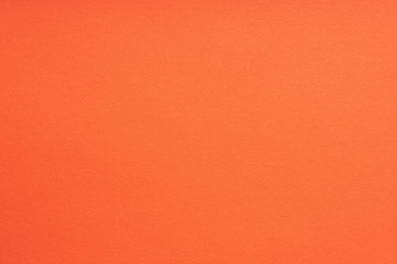 Paper background coral color. Rough paper texture. Closeup. Macro.