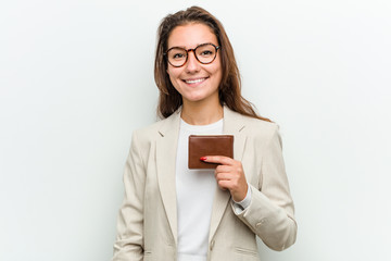 Young european business woman holding a wallet happy, smiling and cheerful.