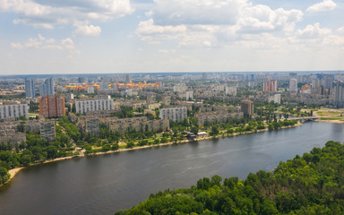 Fototapeta na wymiar Urban aerial view photo from drone of cityscape, skyline and coastline of Dnieper River near Rusanivka island at summer time. (Kyiv, Kiev) Ukraine.