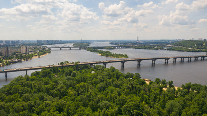 Aerial top view on road bridge across the Dnieper River in city at summer or spring time. (Kyiv, Kiev) Ukraine.