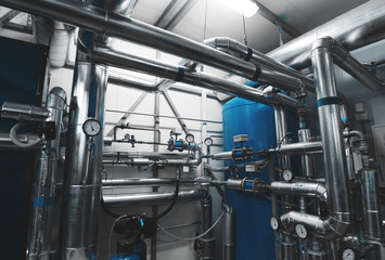Boiler room. Water treatment pipes and pressure gauges installed for pressure control. Expansion Tank. Ventilation System. Blue toning
