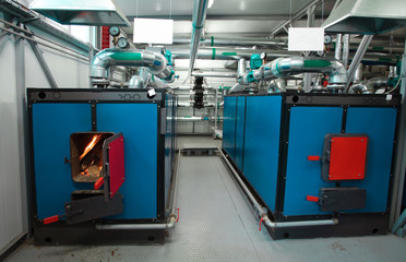 water-heating solid fuel boiler with open firebox and burning fire, installed in the boiler room