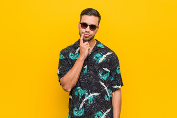 Fototapeta premium Young filipino man wearing summer clothes looking sideways with doubtful and skeptical expression.