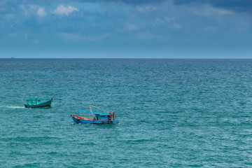 Two fishing boats crossing each off the waters of the Gulf of Thailand