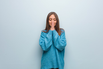 Young pretty woman wearing a blue sweater praying very happy and confident
