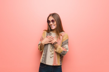 Young hippie woman on pink background doing a romantic gesture