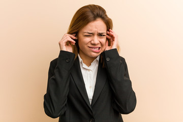 Young caucasian business woman covering her ears with her hands.