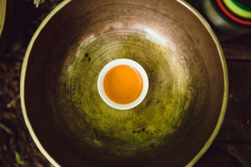 little white cup with tea in the Tibetan Singing Bowl. ceremony