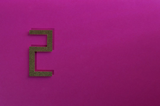 gold number two on pink background