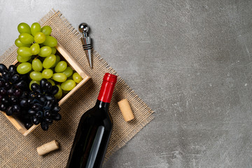 Wooden box with grapes bowl with wine on concrete background. Copy space.