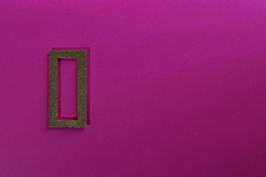 gold number zero on pink background