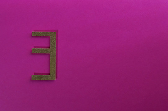 gold number three on pink background