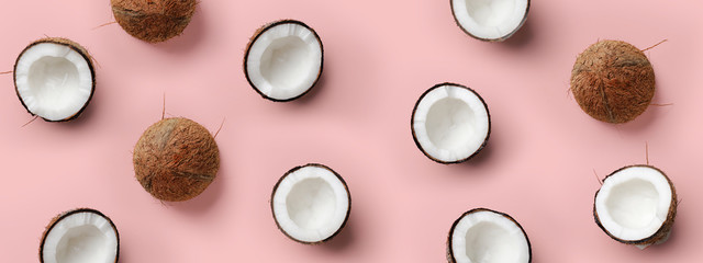 Pattern with ripe coconuts on pink background. Top View. Copy Space. Pop art design, creative summer concept. Half of coconut in minimal flat lay style