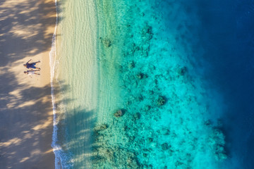 Aerial view of a people couple on the beach. Vacation and adventure. Beach and turquoise water. Top view from drone at beach, azure sea and relax couple. Travel and relax - image