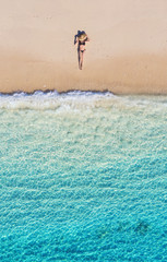 Obrazy  Widok z lotu ptaka dziewczyny na plaży. Wakacje i przygoda. Plaża i turkusowa woda. Widok z góry z drona na plaży, lazurowe morze i relaksująca dziewczyna. Podróżuj i relaksuj się - obraz