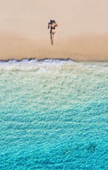 Luftaufnahme eines Mädchens am Strand. Urlaub und Abenteuer. Strand und türkisfarbenes Wasser. Draufsicht von der Drohne am Strand, azurblaues Meer und Entspannungsmädchen. Reisen und entspannen - Bild © biletskiyevgeniy