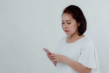 Asian beautiful woman Standing in a white shirt Mobile phone stand press Prepare to make a call. With a happy smile With a white background