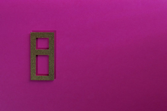 gold number eight on pink background