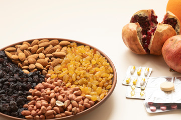 Pills and capsules in white background with fresh fruits. Multivitamins and supplement from fruits concept. Nuts mixed and fresh fruit to raise immunity 