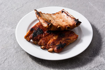 Grilled barbecue ribs on gray stone background