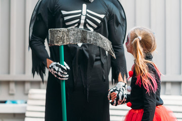 Child with skeleton , dressed in costume for Halloween party.