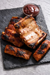 Grilled barbecue ribs on gray stone background