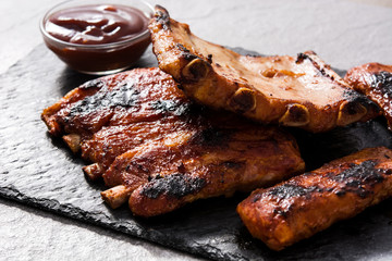 Grilled barbecue ribs on gray stone background