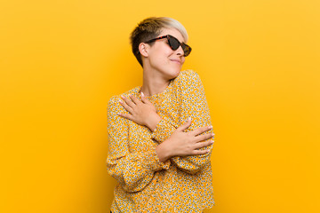 Young curvy woman wearing a floral summer clothes hugs, smiling carefree and happy.