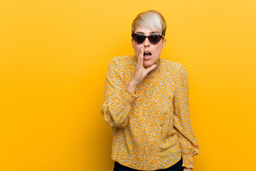 Fototapeta premium Young curvy woman wearing a floral summer clothes is saying a secret hot braking news and looking aside