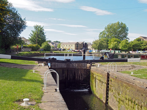 a view of the lock gates at the entrance to brighouse basin and moorings on the calder and hebble navigation canal in calderdale west yorkshire