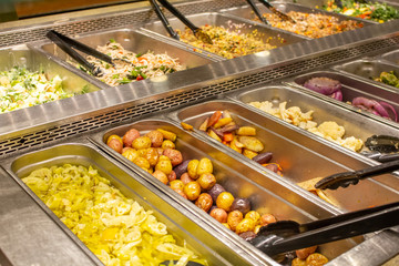 Several options of food to choose from at the meal prep area of a grocery store